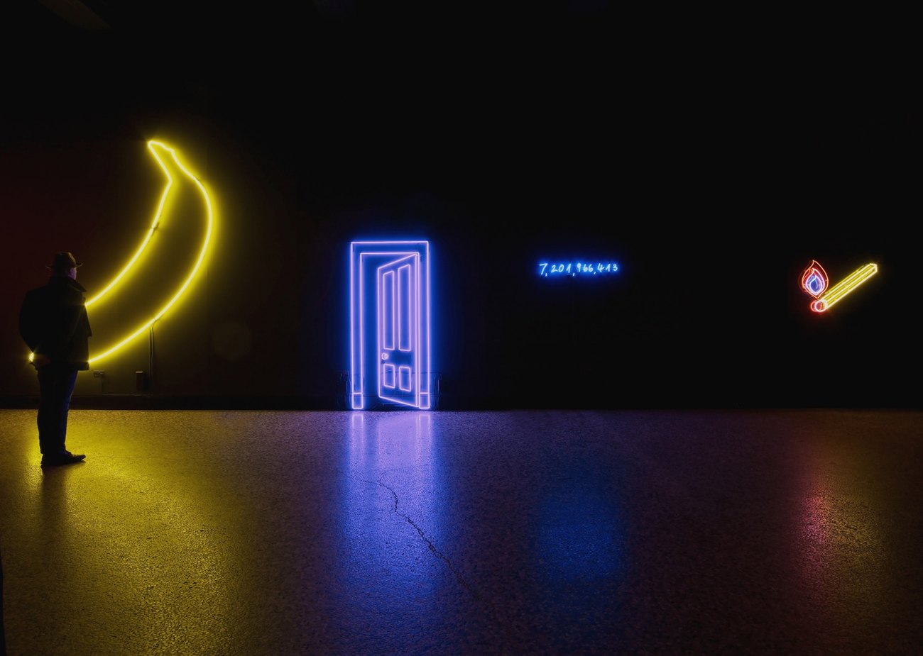 Yellow neon banana, purple neon door, blue neon numbers, yellow and red neon lighted match stick, all on black backdrop