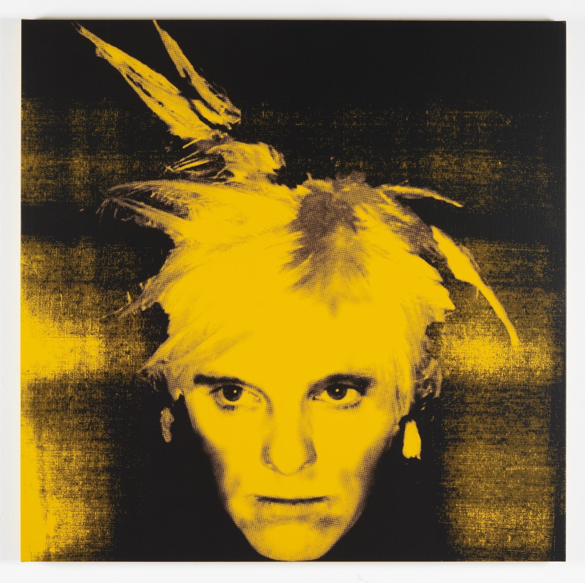 A yellow image of a man's face (Gavin Turk, as Andy Warhol) on a black background