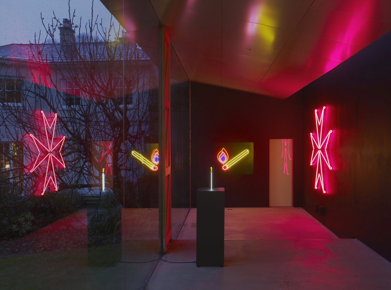 A white neon candle; a yellow and red neon matchstick with a flame; a red neon maltese cross against a backdrop 