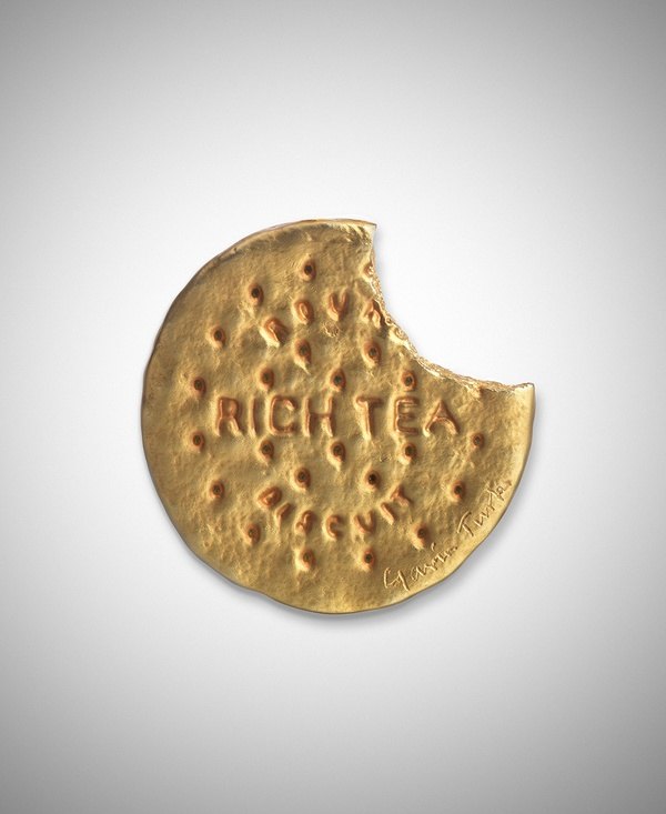 A rich tea biscuit with a bit taken out of it, cast in gold