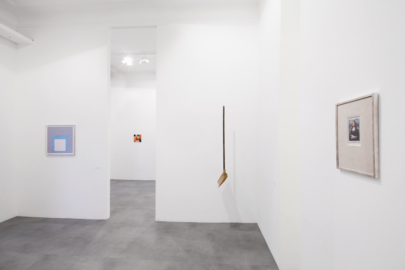 A series of artworks in a gallery space with black floors and white walls
