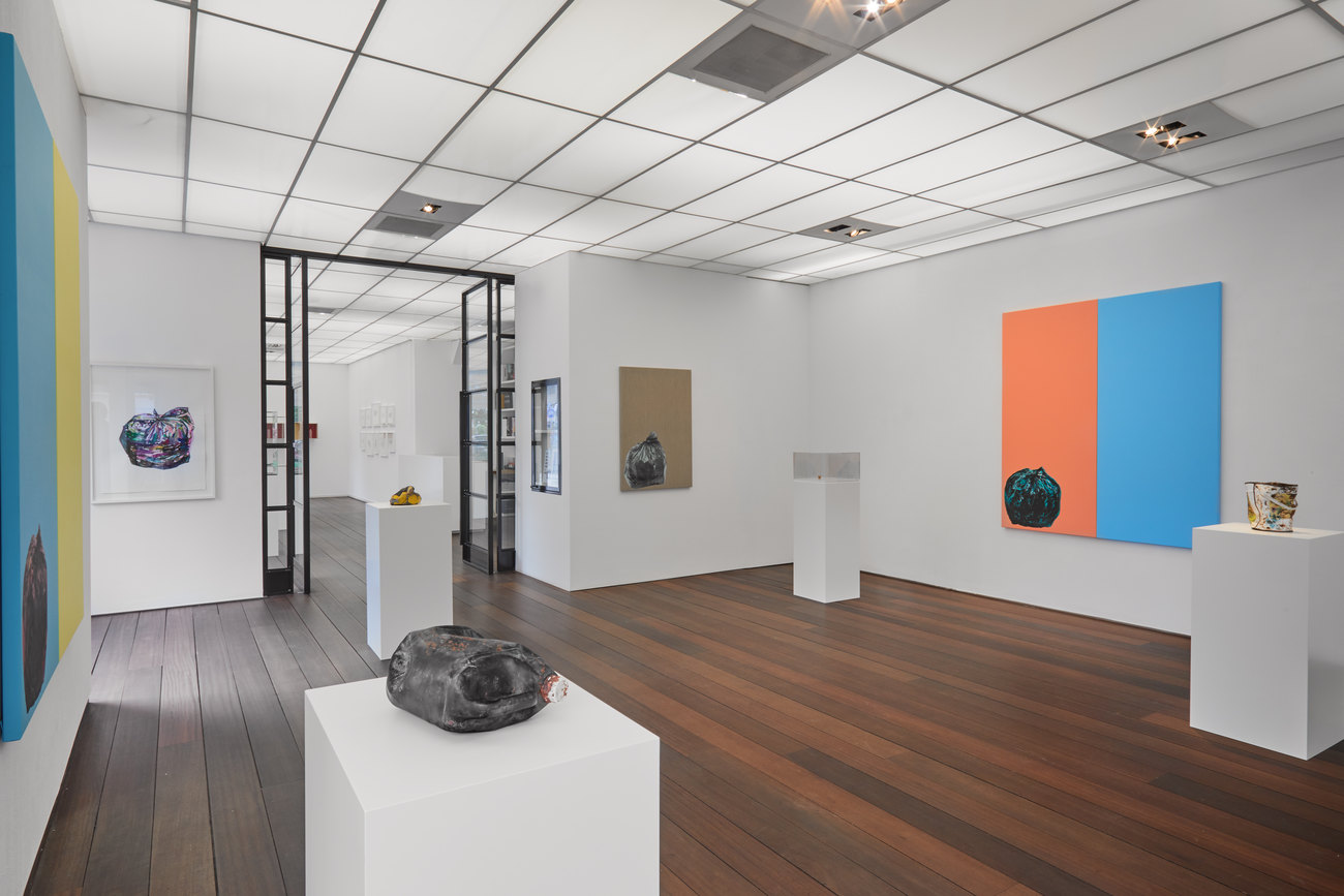 Installation photo of solo show by Gavin Turk shows three cast painted bronze works, resembling discarded objects & paintings on the walls of Bin Bags 