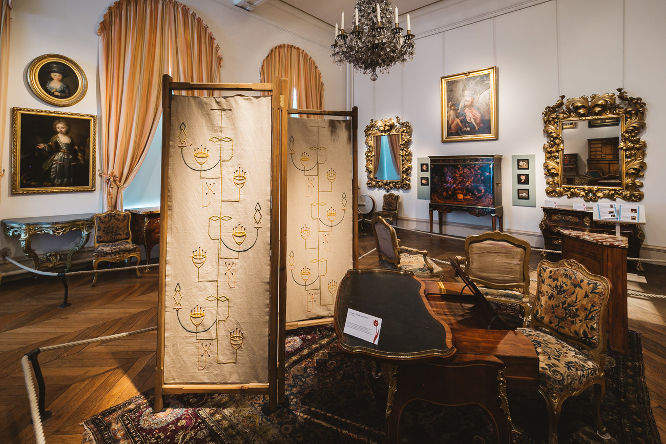 Image shows a furnished room, with carpet and table and chairs