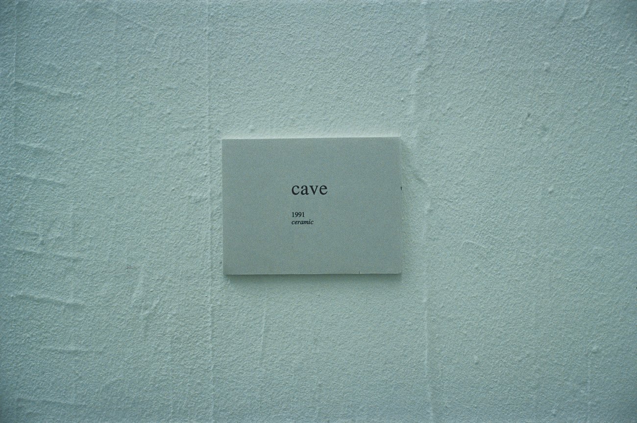 Artwork Card on the wall of the space, says cave 1991 ceramic 