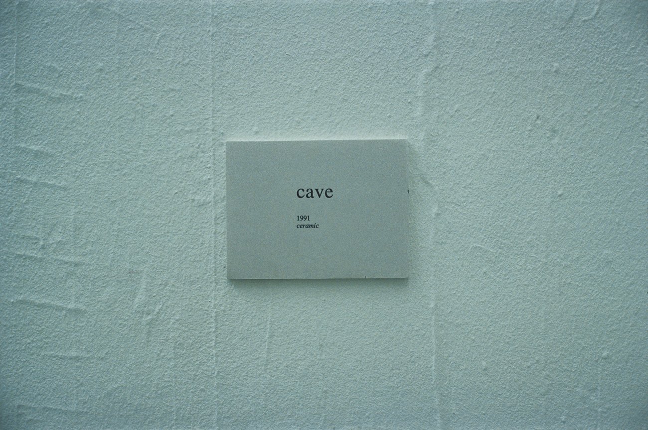 Artwork Card on the wall of the space, says cave 1991 ceramic