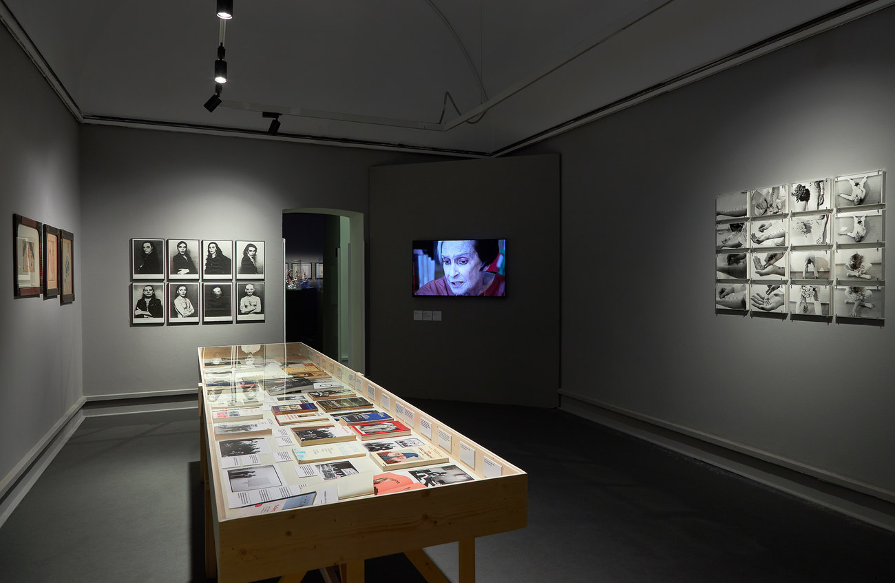 Installation photo of a group exhibition, on one wall artist self portraits, the other wall aktionist photos