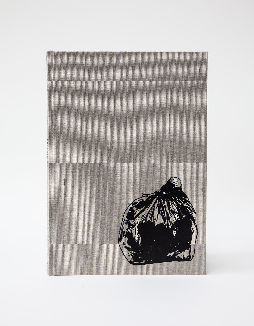 An image shows a book with a linen cover, the front shows a printed bin bag