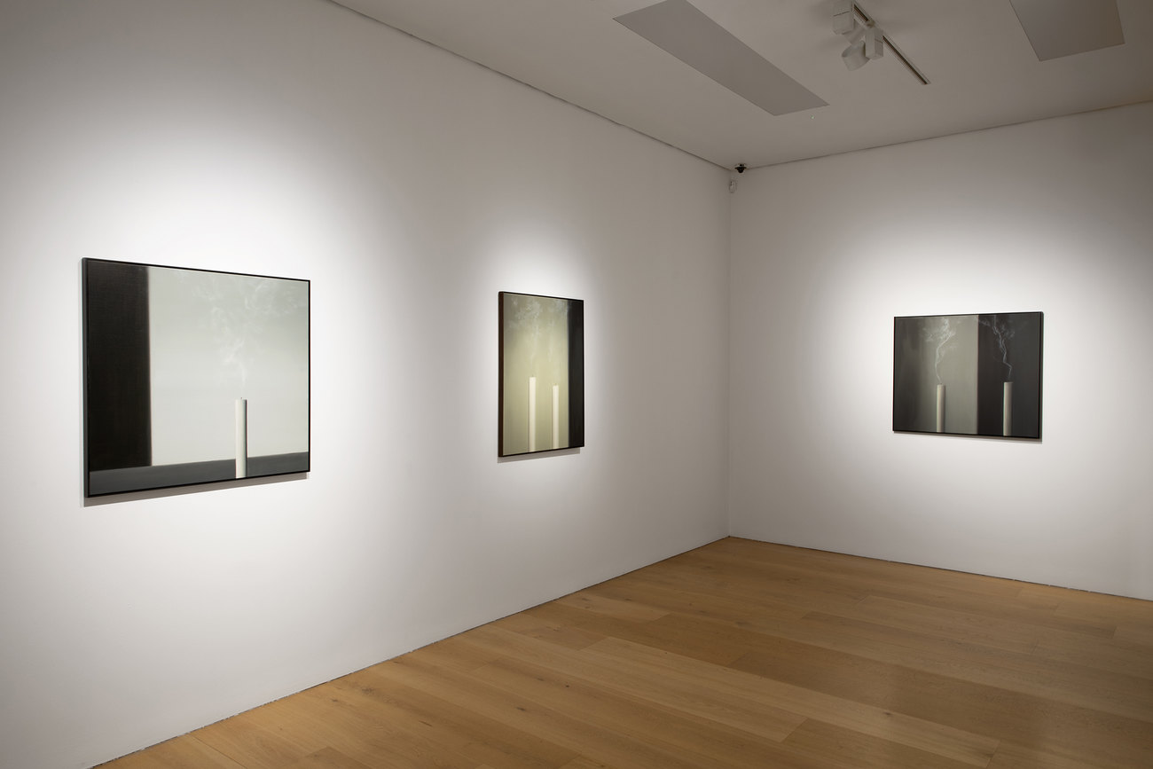 Installation photo of paintings with just extinguished candles