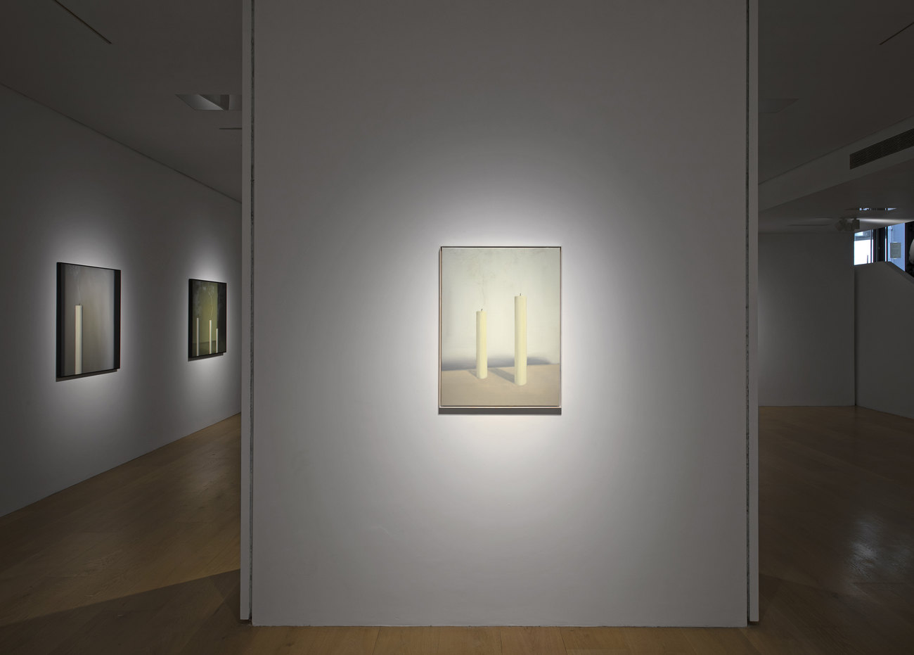 Installation photo of paintings with just extinguished candles