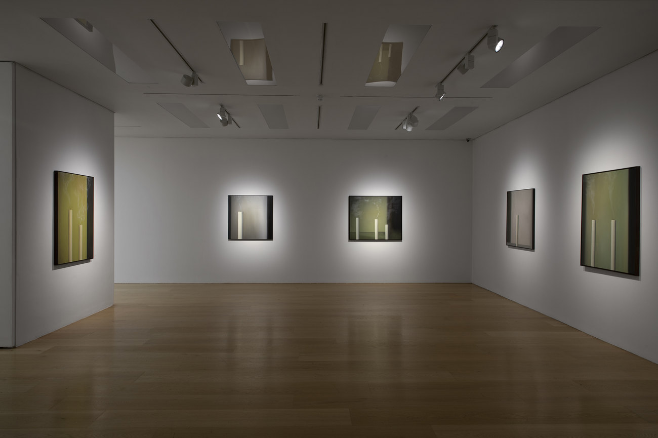 Installation photo of paintings with just extinguished candles