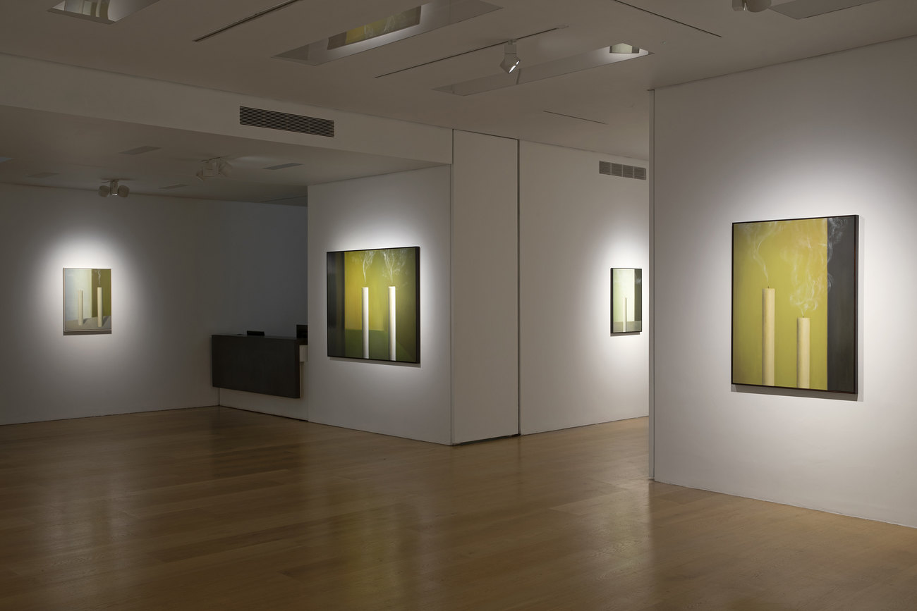 Installation photo of paintings with just extinguished candles