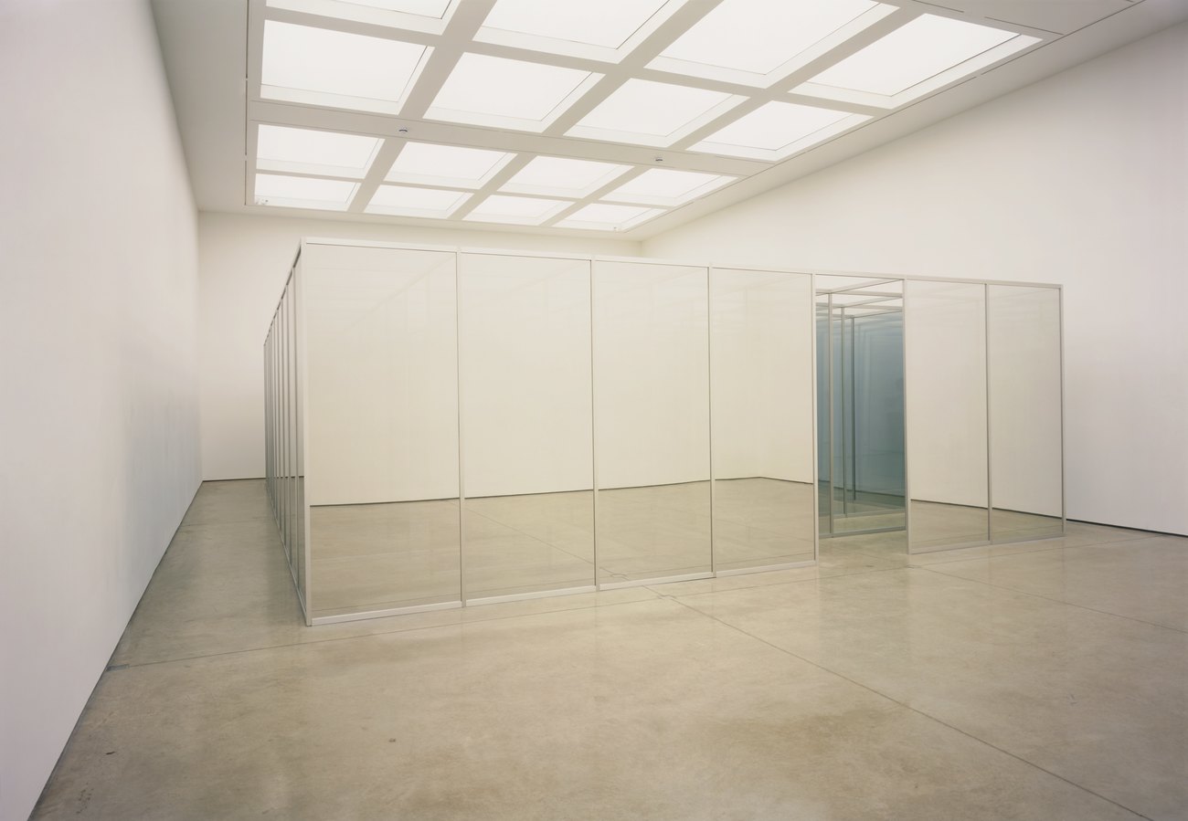 Image of a mirrored construction in a white walled gallery 