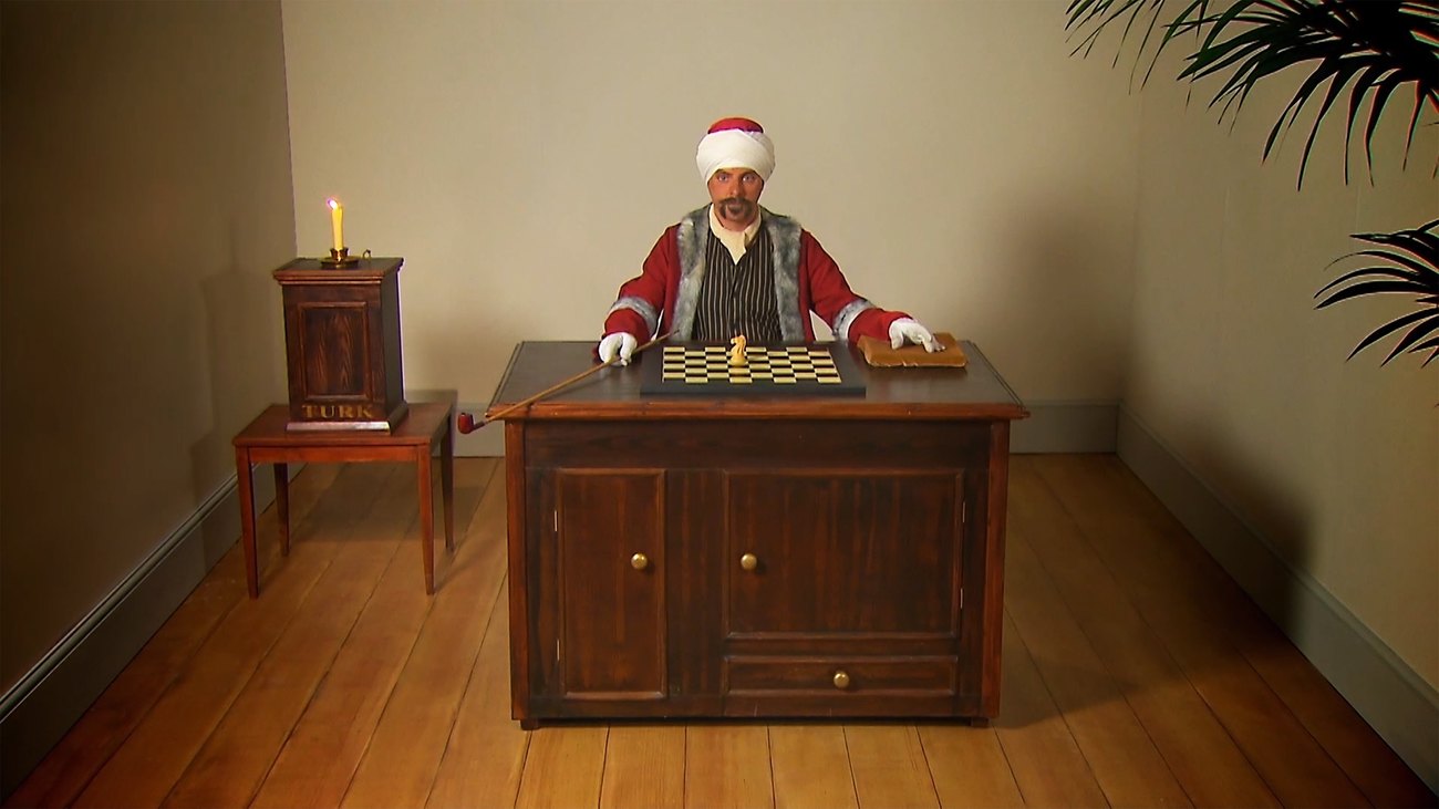 Image shows the Artist Gavin Turk enacting The Mechanical Turk