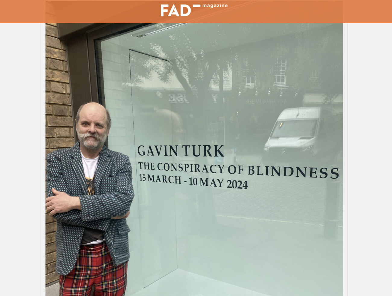 Image shows a screenshot from the Fad article of Gavin Turk in front of signage for his new exhibition