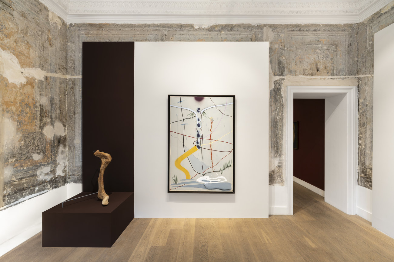 Photo shows a sculpture on a brown plinth and an abstract painting installed to the side
