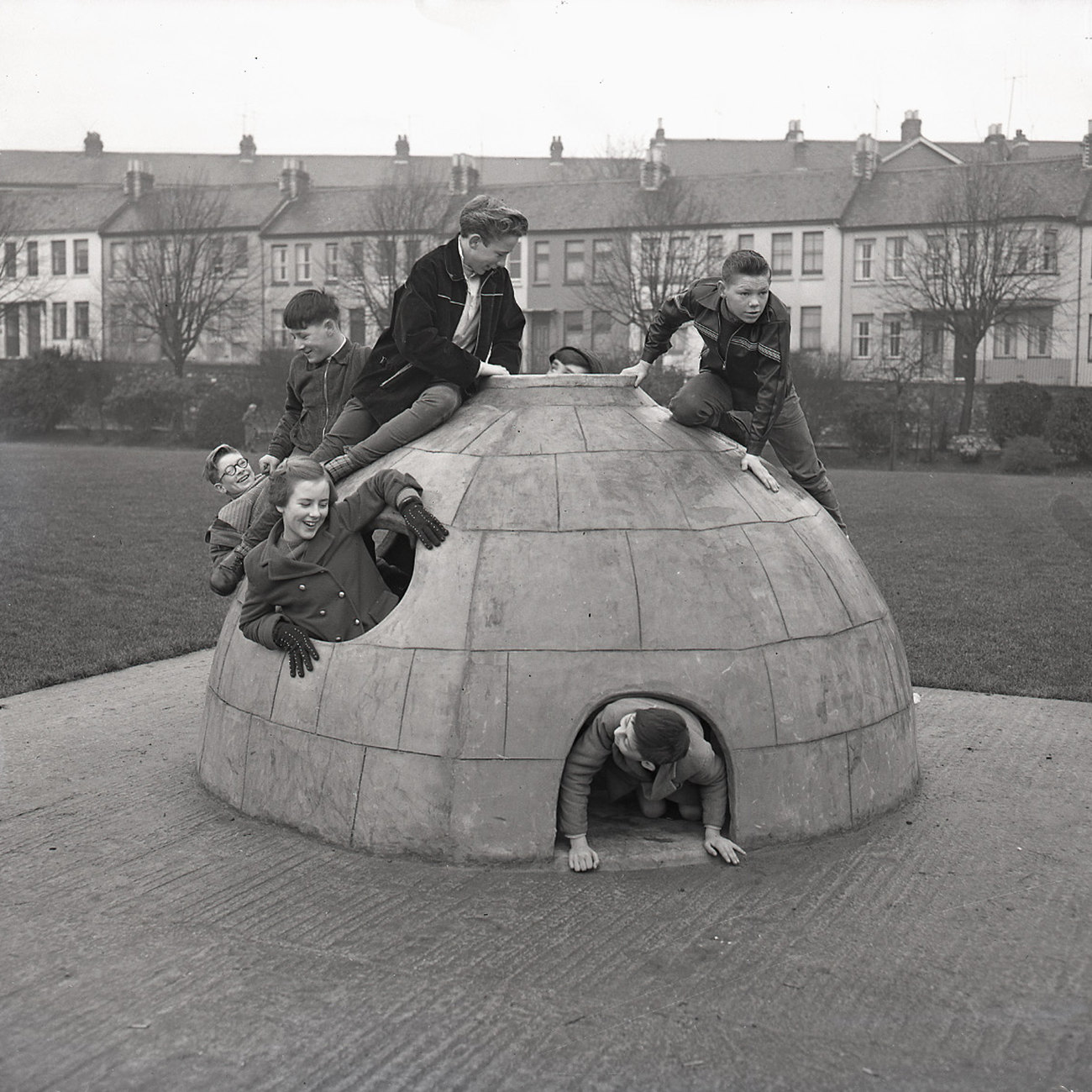 This vintage photograph shows children playing on a concrete igloo climbing frame at Tothill Children's Playground in Plymouth on December 31, 1958